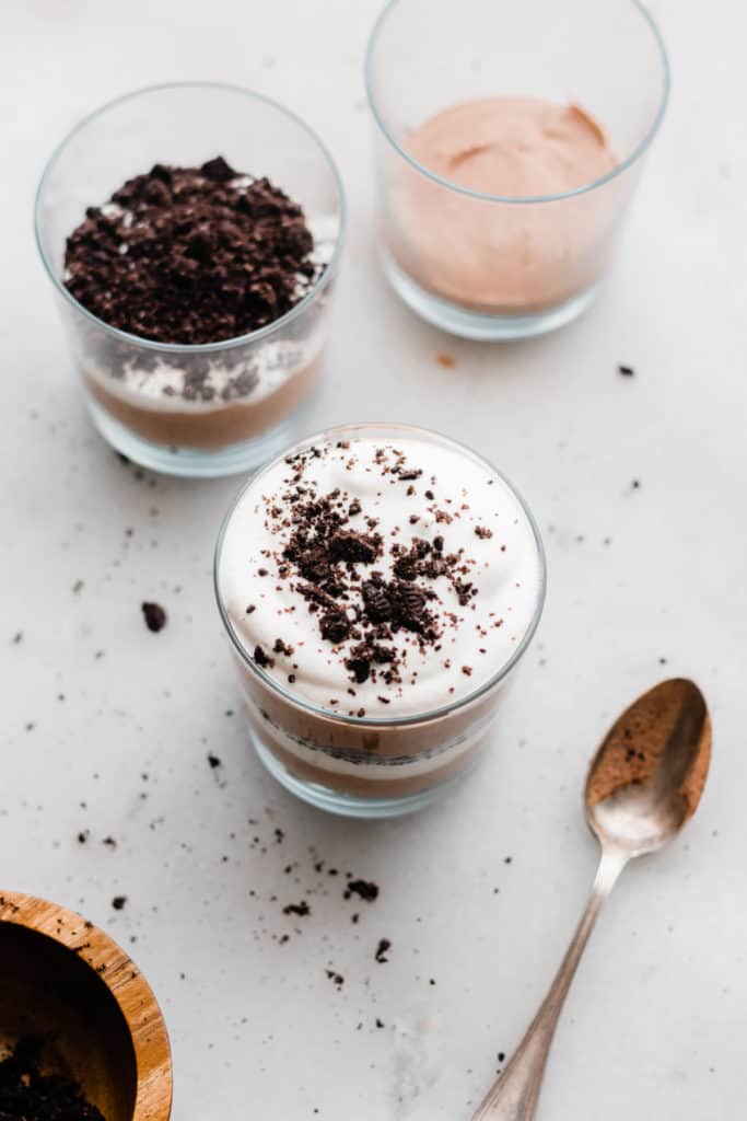 Bailey's Chocolate Mousse Parfaits - Silky smooth layers of Irish cream-infused whipped cream, chocolate whipped cream, and crushed oreos make up these delightful personal-sized desserts! These desserts are so easy to make and are no-bake! Perfect for St. Patrick's Day or any other celebration. #stpatricksday #stpatricksdaydessert #dessertrecipes #chocolaterecipes #nobakedesserts #nobakerecipes #glutenfreedesserts #chocolatedessert #bluebowlrecipes | bluebowlrecipes.com