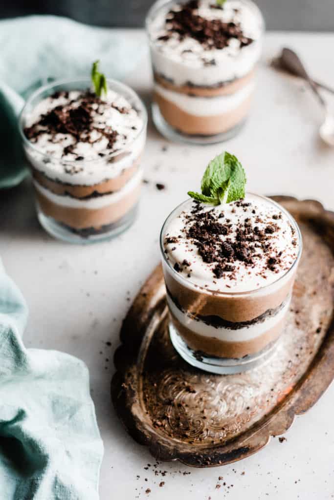Bailey's Chocolate Mousse Parfaits - Silky smooth layers of Irish cream-infused whipped cream, chocolate whipped cream, and crushed oreos make up these delightful personal-sized desserts! These desserts are so easy to make and are no-bake! Perfect for St. Patrick's Day or any other celebration. #stpatricksday #stpatricksdaydessert #dessertrecipes #chocolaterecipes #nobakedesserts #nobakerecipes #glutenfreedesserts #chocolatedessert #bluebowlrecipes | bluebowlrecipes.com