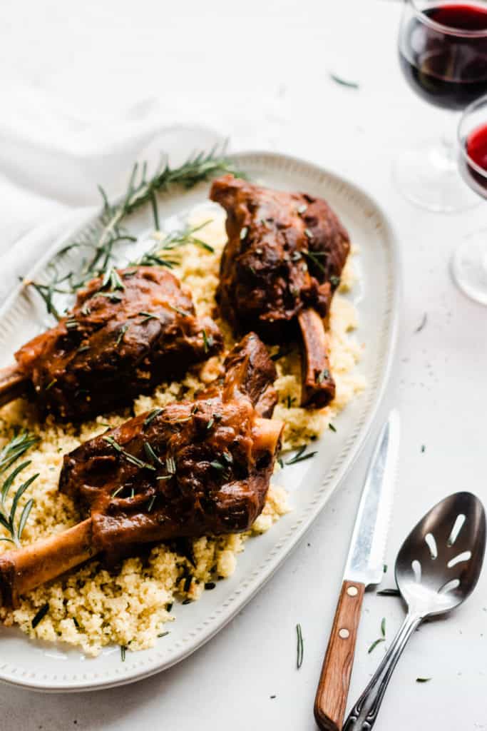 Lamb shanks and couscous on a plate with rosemary
