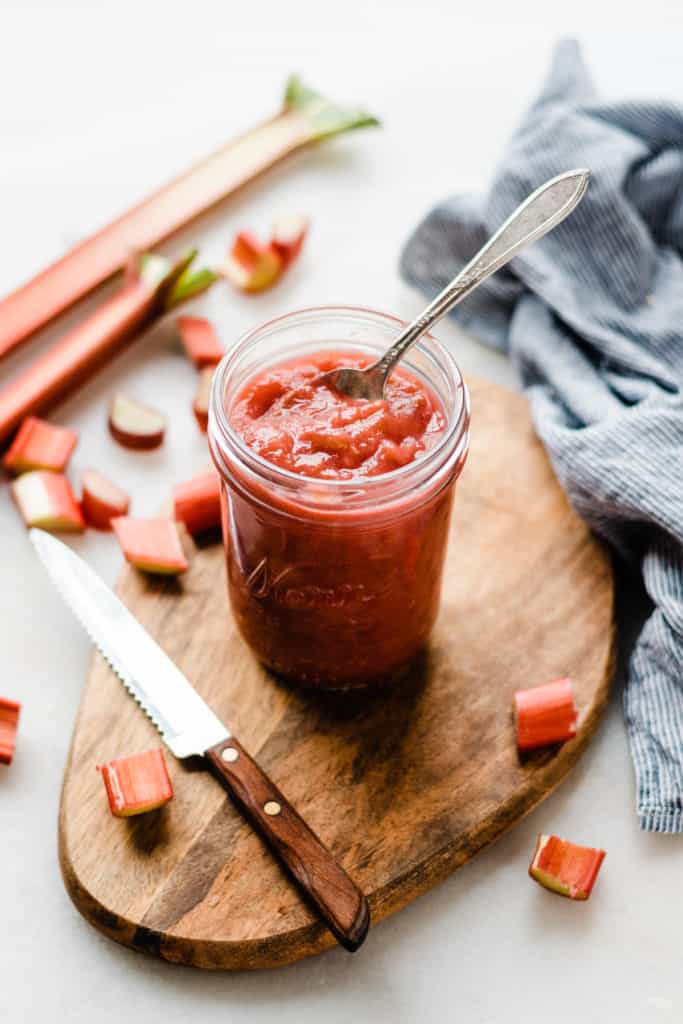 Jar of strawberry rhubarb sauce on cutting board
