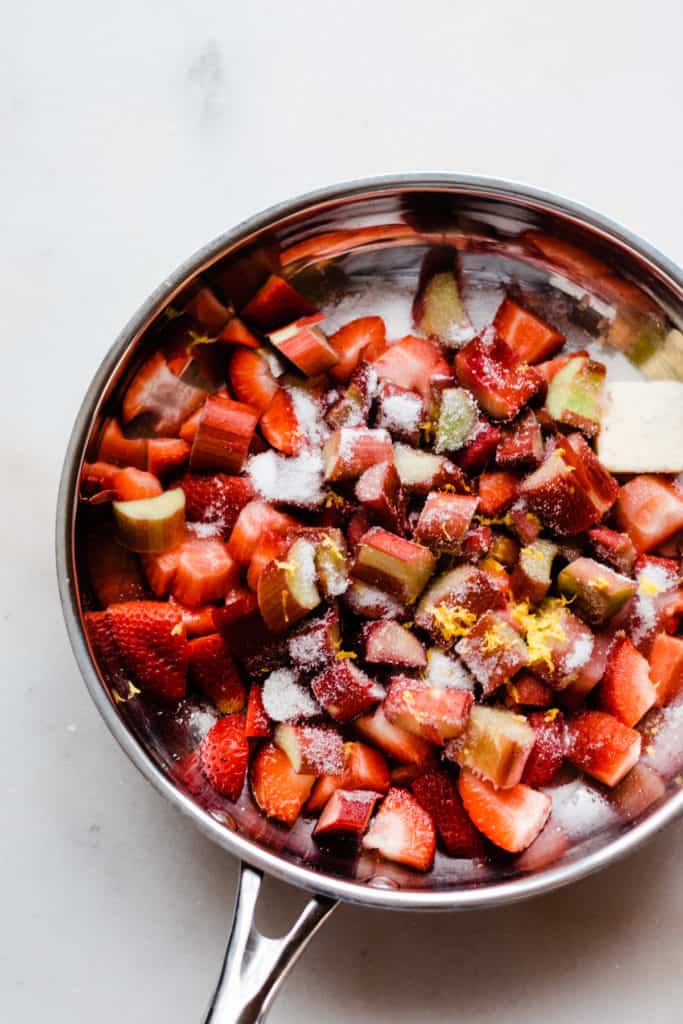 Chopped strawberries and rhubarb in a bowl with sugar