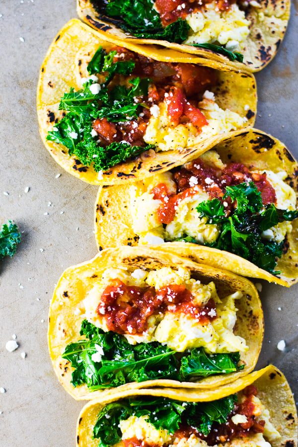 Quick Breakfast Tacos - Crazy easy breakfast tacos, made with soft scrambled eggs, sautéed kale, fire-roasted tomato salsa, corn tortillas and a generous sprinkle of cheese. So delicious! #easyrecipes #breakfastrecipes #glutenfreebreakfast #tacos #breakfasttacos #vegetarianrecipes #bluebowlrecipes | bluebowlrecipes.com