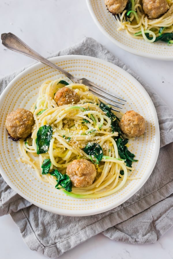 Meal Prep Meatballs with Zoodles - A quick and easy way to meal prep! Baked turkey parmesan meatballs, zoodles mixed with pasta in a garlicky-butter sauce with fresh spinach and herbs - YUM! Freeze half of the meatballs for later. #mealprep #healthydinner #dinnerrecipes #zoodles #turkey #meatballs #easyrecipes #healthyrecipes #bluebowlrecipes | bluebowlrecipes.com