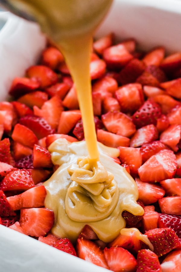 Pouring caramel over strawberries