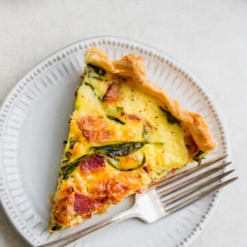 A slice of breakfast quiche on a plate.