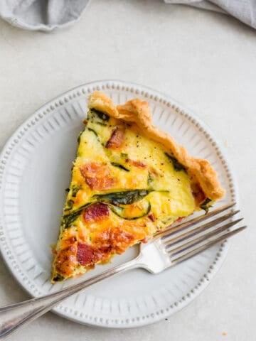 A slice of breakfast quiche on a plate.