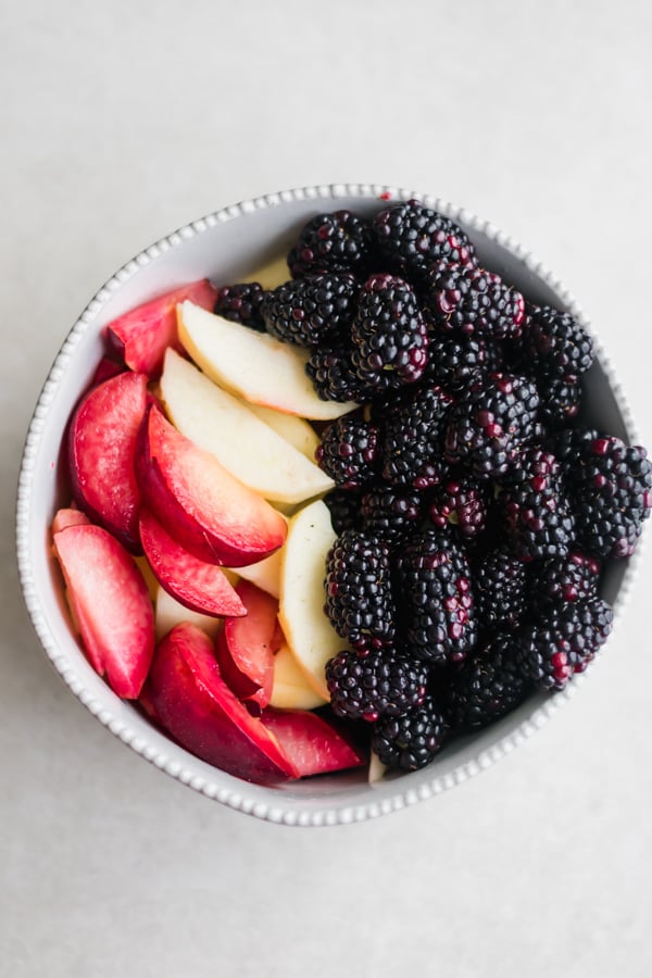 Bowl of apples, plums, and blackberries