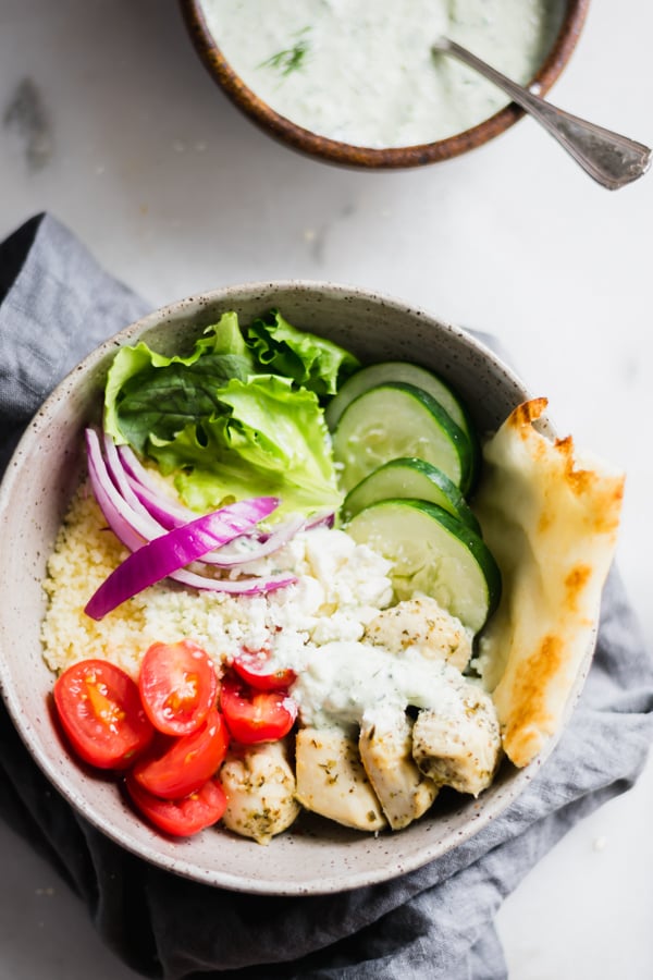 A chicken gyro bowl and a bowl of tzatziki sauce.