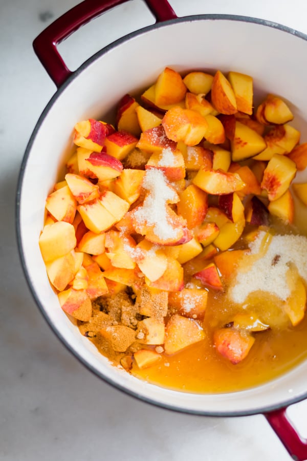Chopped peaches in a pot with sugars.