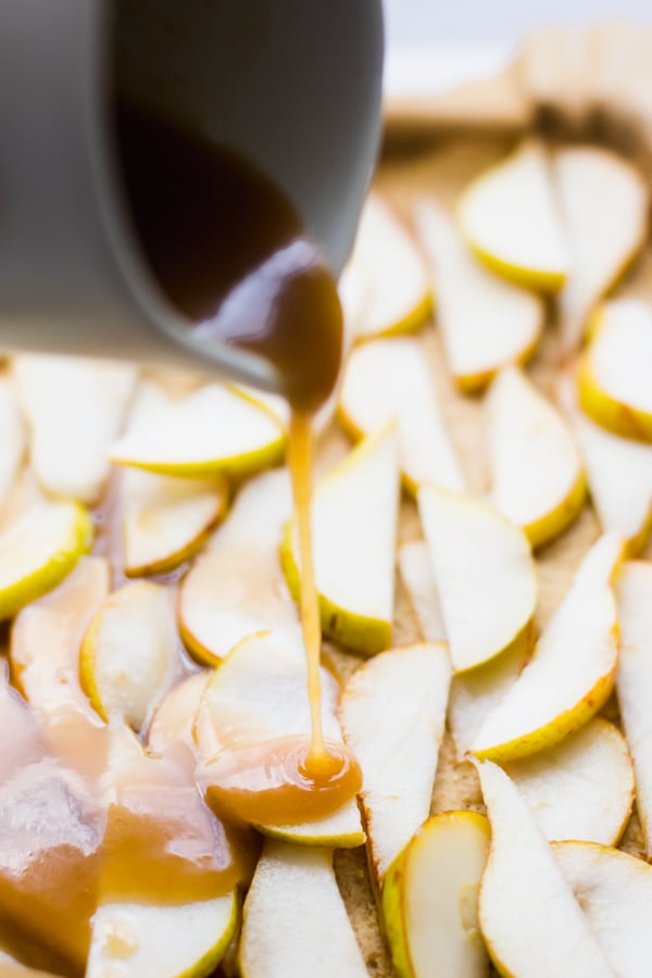Caramel sauce pouring over sliced pears.