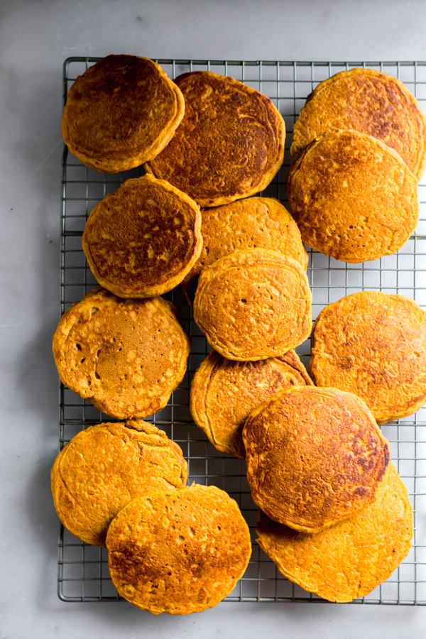 Fluffy pumpkin pancakes on a cooling rack.