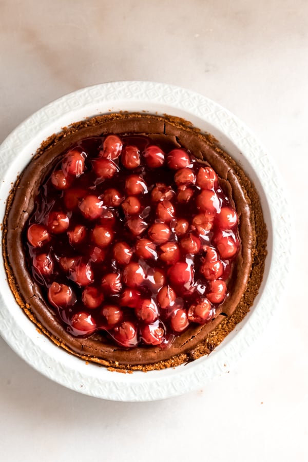 Chocolate cherry cheesecake in a white pan.