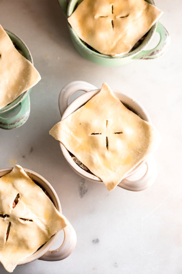 Puff pastry layers on top of pot pie bowls.