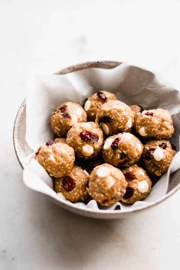 Cranberry White Chocolate Energy Bites - Perfect for make-ahead breakfasts, snacks, or a healthy treat! They're gluten-free, almost vegan, dairy-free, and refined sugar free. Plus, they basically taste like little bites of cookie dough! #cranberry #whitechocolate #energybites #energyballs #vegan #glutenfree #dairyfree #healthysnack #healthytreat #makeaheadbreakfast #healthyrecipes #bluebowlrecipes | bluebowlrecipes.com