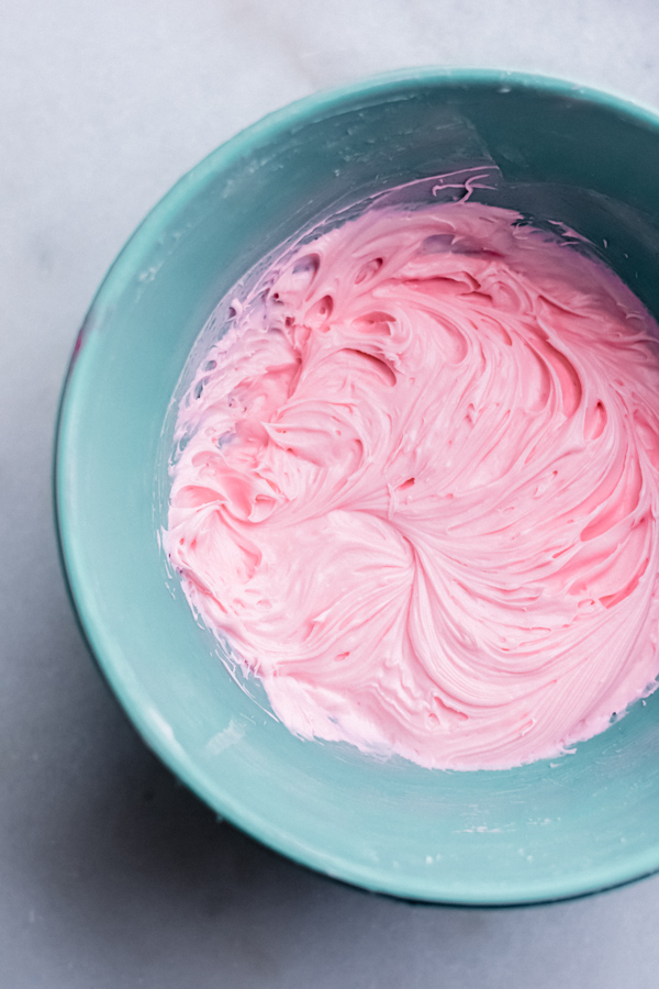 Pink frosting in a bowl.