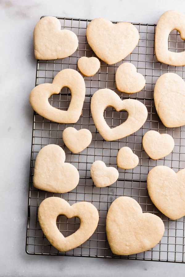 Baked heart cookies on a cooling rack.