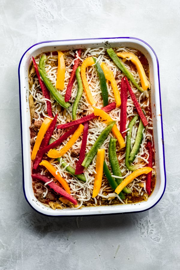 Peppers and shredded cheese on top of pasta bake.