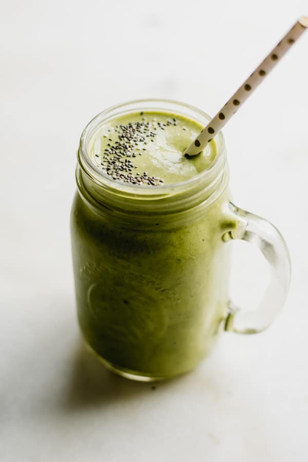 Creamy green smoothie in a glass jar.