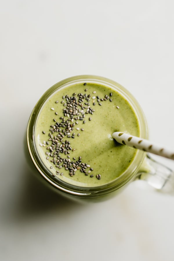 Top view of a green smoothie in a glass jar.