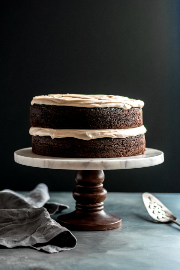 Guinness chocolate cake with brown butter frosting on a cake stand.