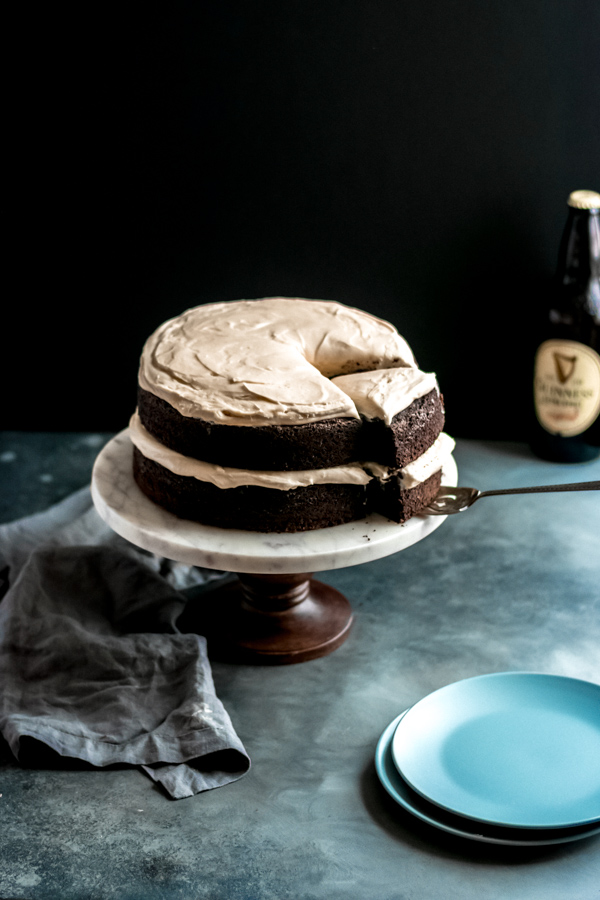 Guinness chocolate cake with brown butter frosting on a cake stand.