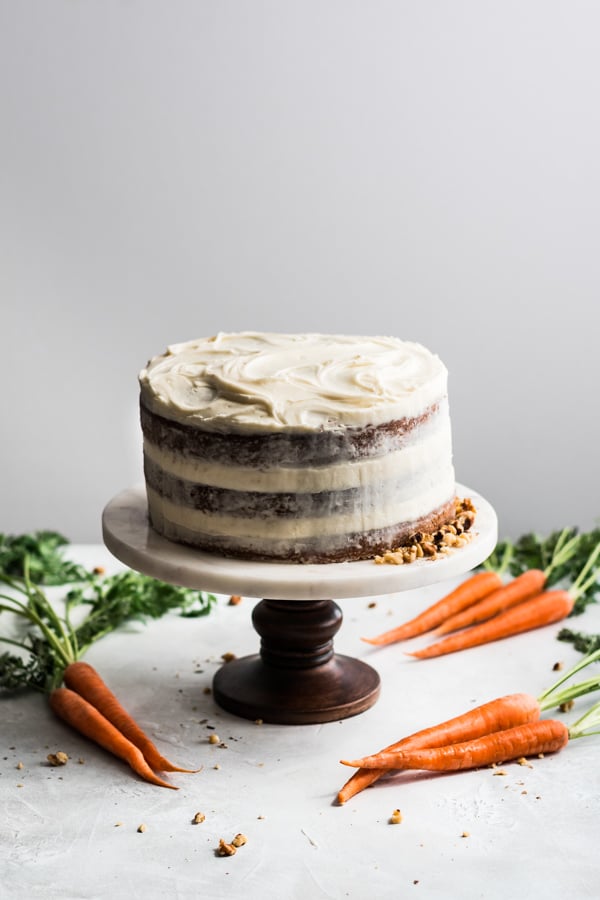 A whole carrot cake on a cake stand.