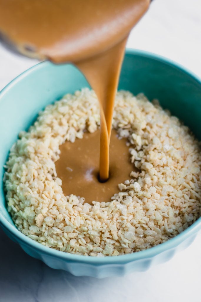 Brown rice syrup poured over rice cereal in a bowl.