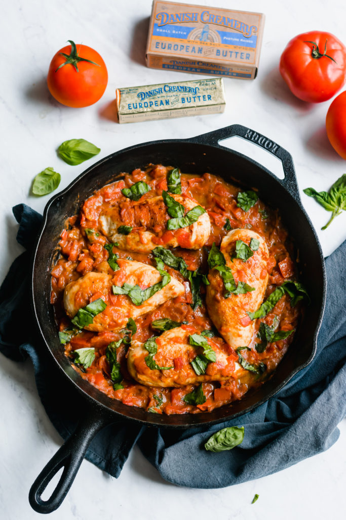 One pan chicken with garlic butter tomato sauce in a skillet.