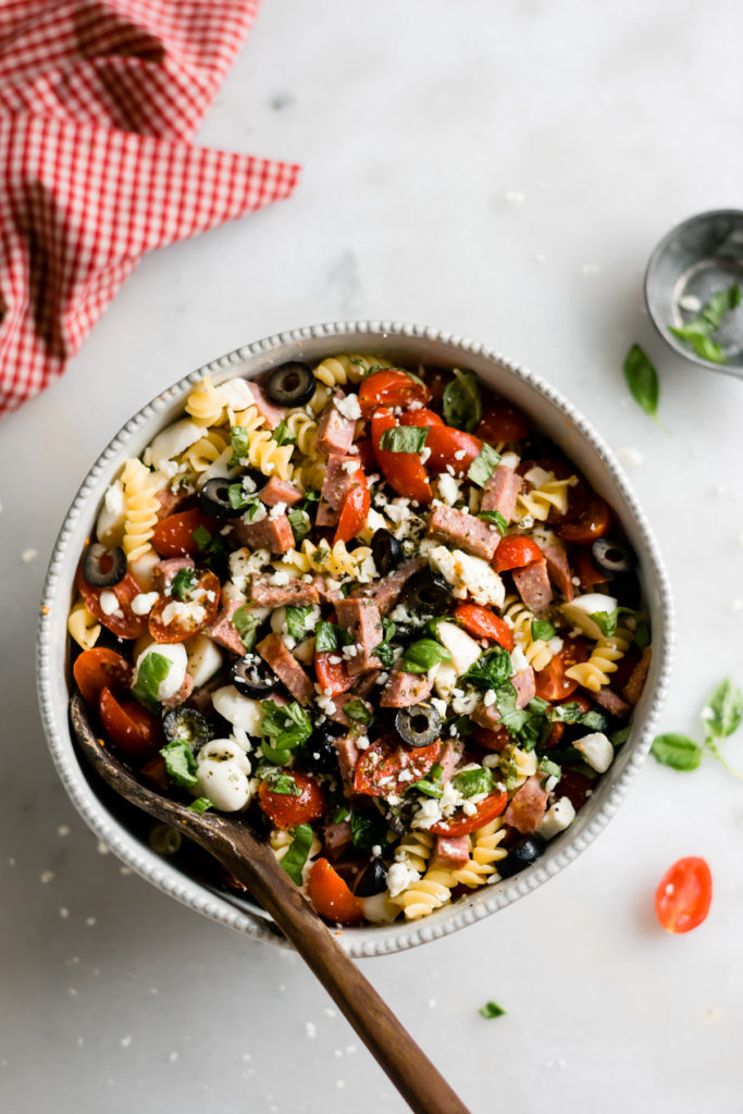 Summer pasta salad with Italian dressing in a bowl.