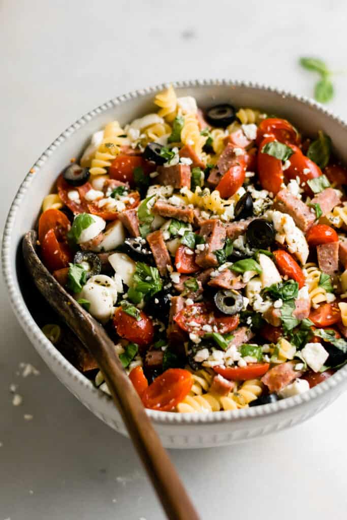 Summer pasta salad with Italian dressing in a large bowl.
