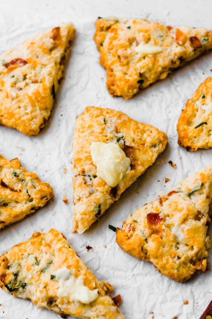 Bacon cheddar chive scones with dollops of butter.