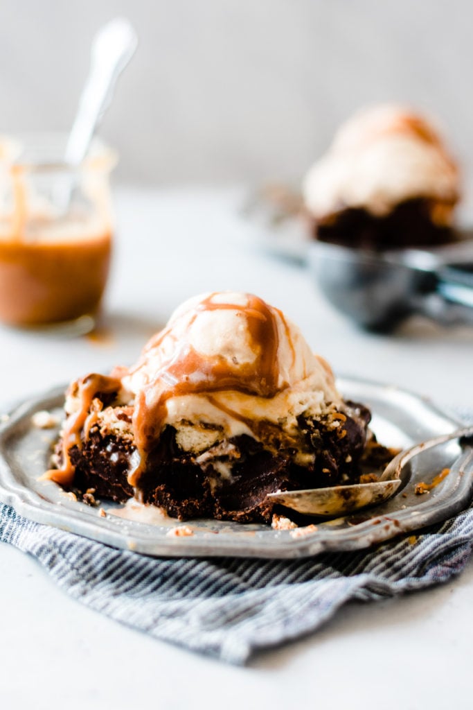 Hot fudge brownie sundaes with Samoa cookies and caramel on a plate.