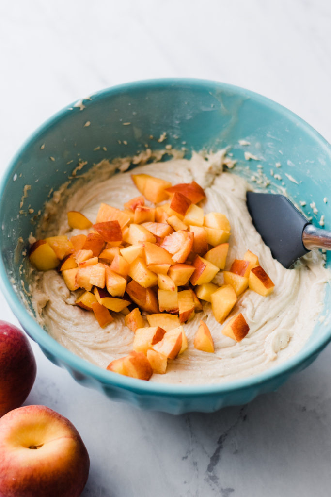 Chopped peaches in a bowl with batter.