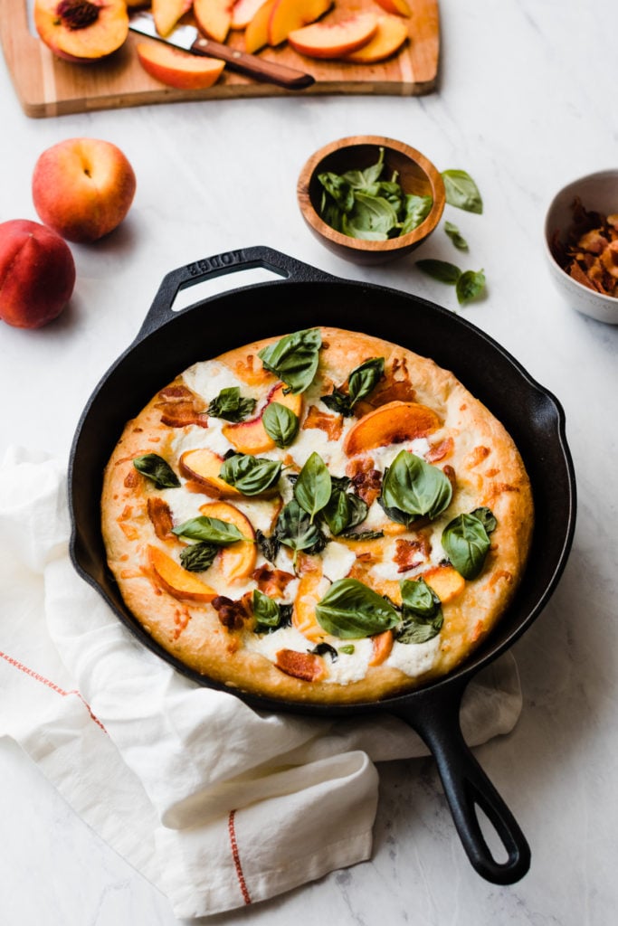 Baked peach pizza in a cast iron skillet.