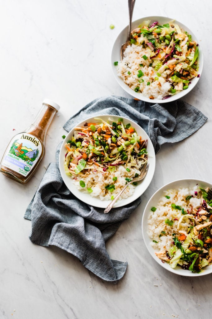 Asian Chicken Bowls with Sesame Dressing - Asian Chicken Bowls are quick, flavorful, and easy to throw together! Made with a mixture of red and green cabbage, carrots, bell peppers, edamame, chicken, and Annie's Asian Sesame Dressing. Serve with rice, chopped almonds, sliced green onion, and a sprinkle of sesame seeds. #chickenrecipes #glutenfreerecipes #glutenfree #healthyrecipes #lunchideas #healthyeating #healthyfood #healthylunch #easyrecipe #bluebowlrecipes | bluebowlrecipes.com