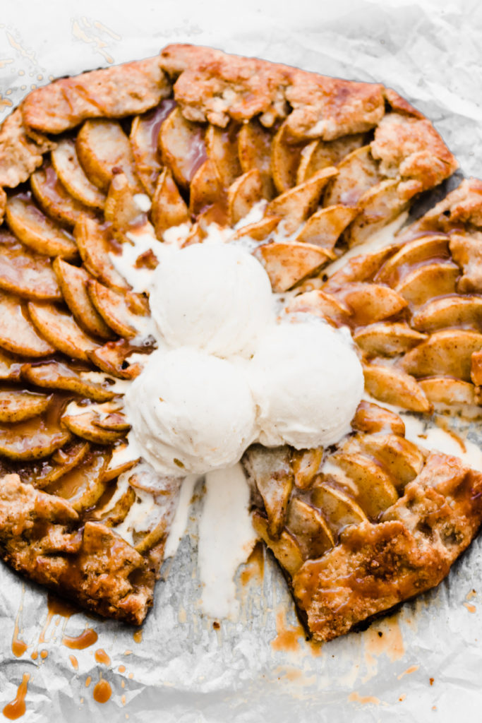 Salted caramel pear galette with scoops of vanilla ice cream.