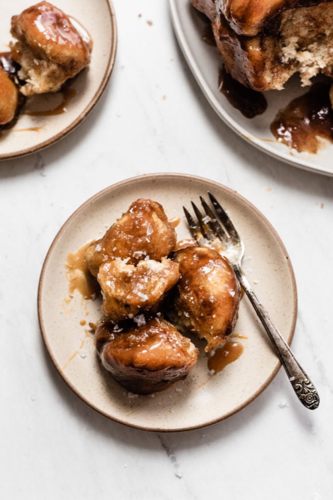 Easy Caramel Apple Cider Monkey Bread - Meet your new favorite fall treat! This Monkey Bread is light and fluffy, super flavorful, & doused in apple cider caramel sauce. This recipe comes together in no time thanks to a little help from pre-made dough. Perfect for brunch, fall gatherings, holiday parties, & game day! #halloweenfood #christmasrecipes #caramel #monkeybread #brunchrecipes #dessertrecipes #dessertideas #dessertfoodrecipes #thanksgivingrecipes #bluebowlrecipes | bluebowlrecipes.com