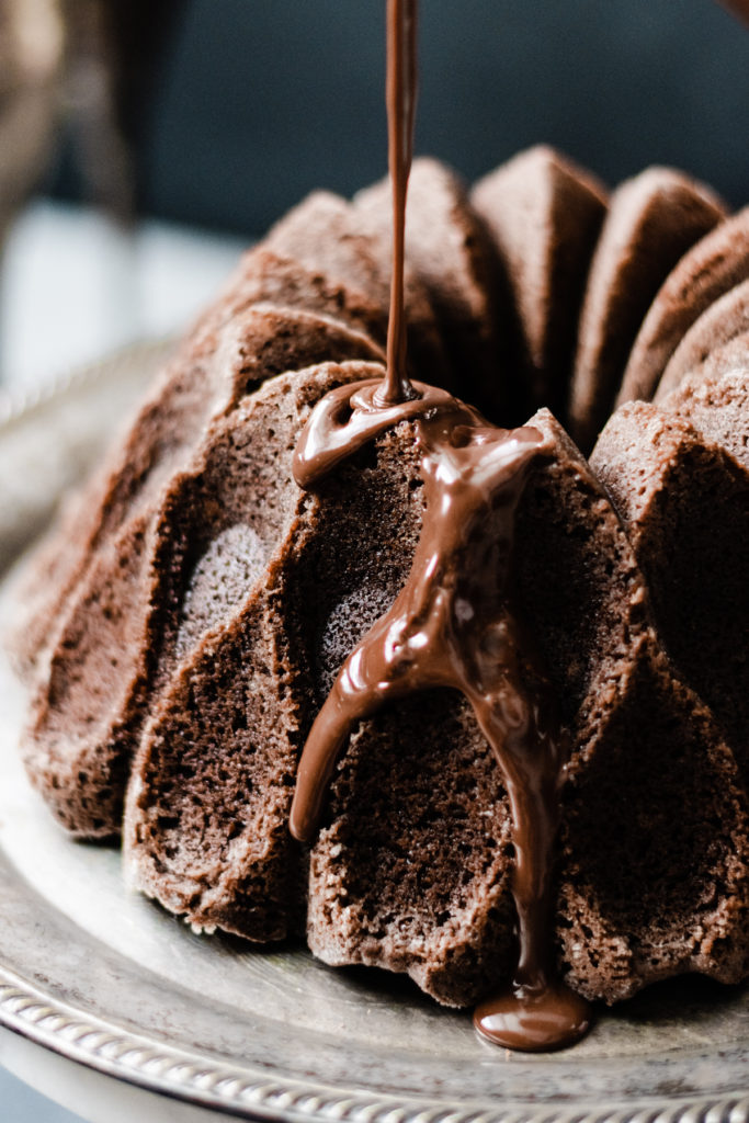 Chocolate Bundt Cake with Chocolate Glaze and Salted Caramel - Introducing the richest Chocolate Bundt Cake! This isn't your average chocolate cake - it's got a secret ingredient that gives it a boost of smooth flavor, and the whole thing is doused in a rich Chocolate Ganache. Serve with Salted Caramel Sauce to take it right over the top! #chocolate #dessert #dessertrecipes #bakingrecipes #halloween #halloweenfood #bundtcake #cake #chocolatecake #caramel #bluebowlrecipes | bluebowlrecipes.com