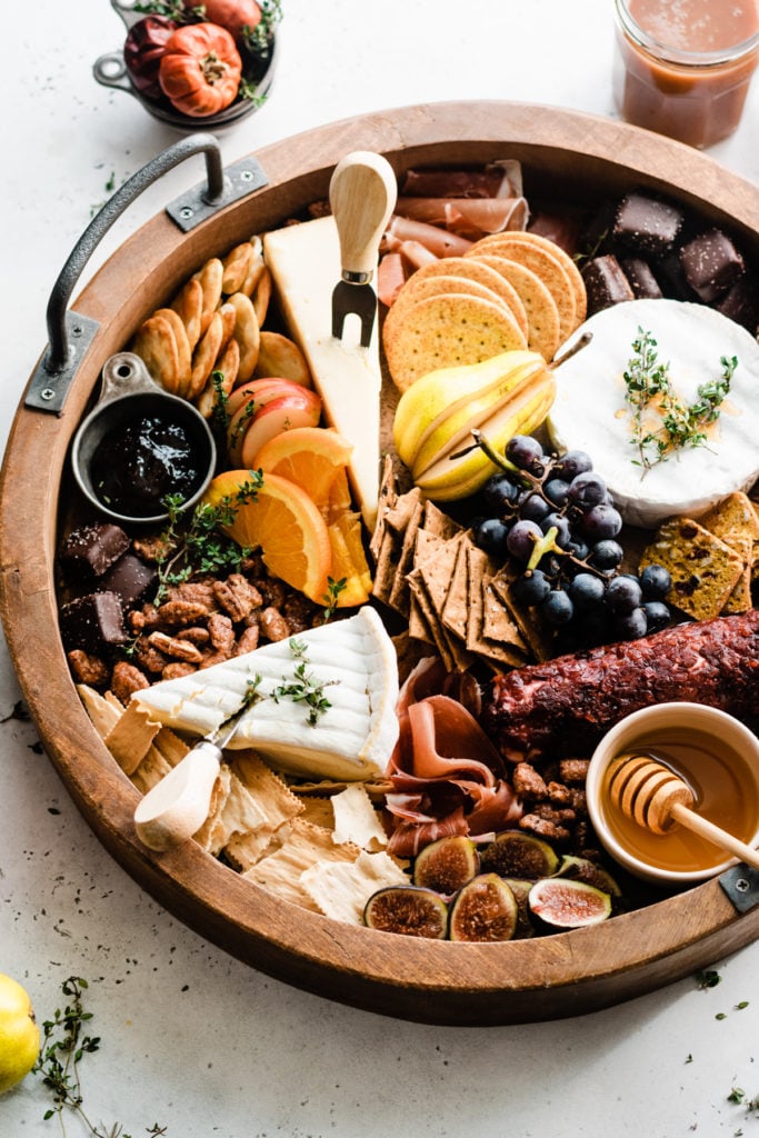 A round wooden cheese board filled with fall's bounty.