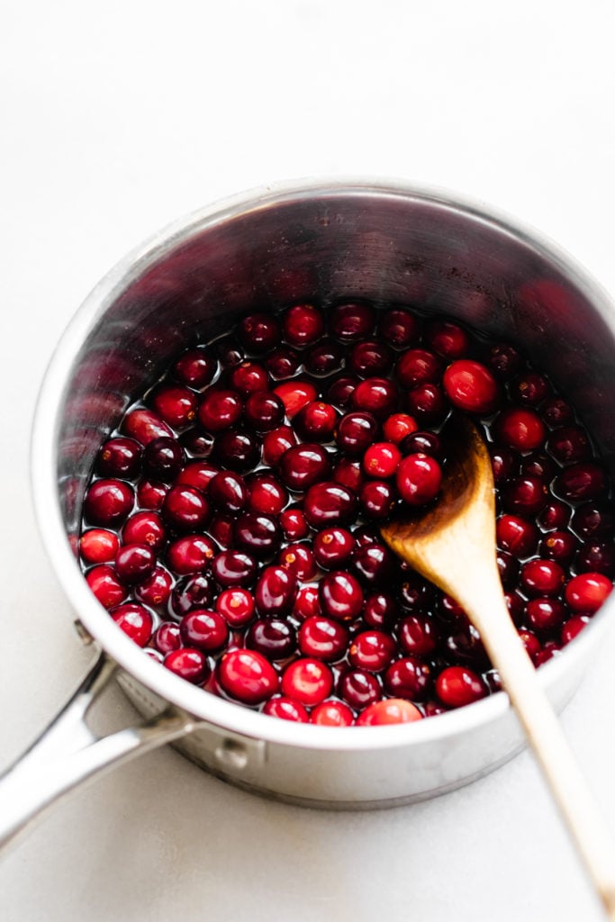 A pot of whole cranberries in the sugar syrup.