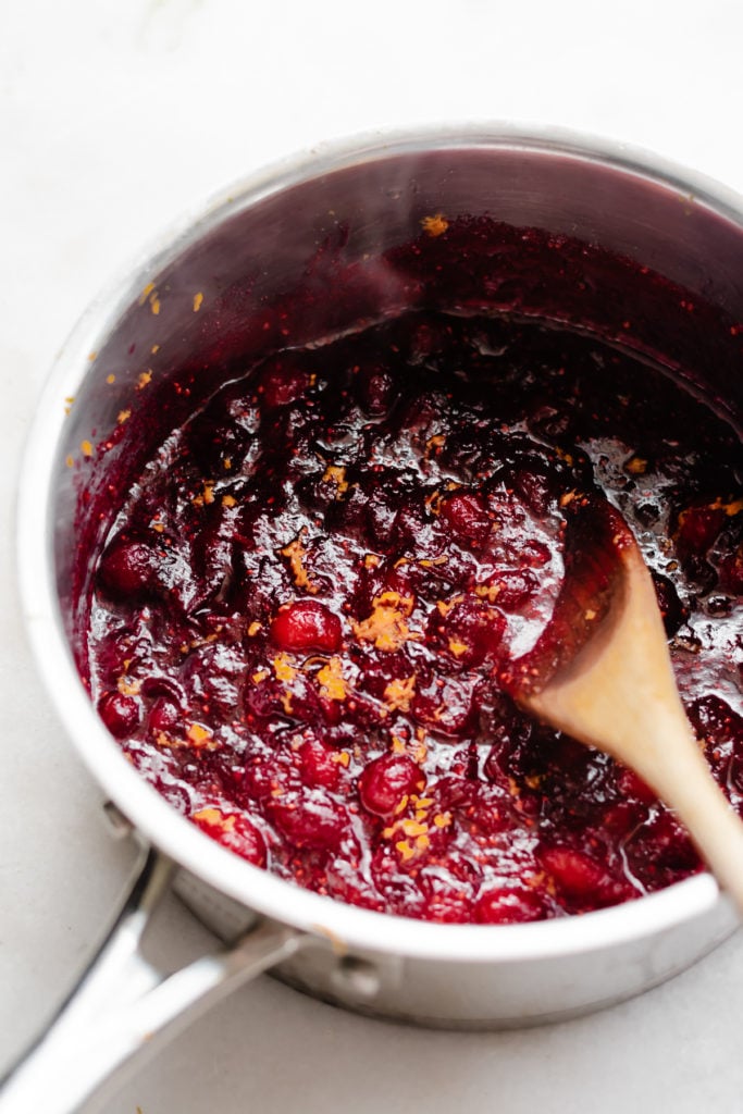 Homemade Cranberry Sauce with Maple Syrup and Bourbon - Homemade Cranberry sauce takes 15 minutes to make + kicks canned sauce to the curb! Flavored with a splash of bourbon, maple syrup, & orange zest. You'll want to eat this stuff straight out of the bowl with a spoon - it's THAT good! #cranberrysauce #thanksgivingrecipes #thanksgivingfood #glutenfreethanksgiving #veganthanksgiving #easycranberrysauce #easythanksgivingrecipes #christmasrecipes #sidedish #bluebowlrecipes | bluebowlrecipes.com