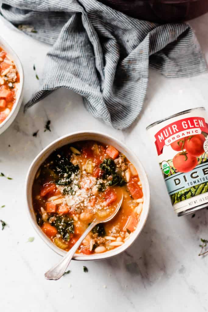 Healthy and Hearty Minestrone Soup - Made with carrots, diced tomatoes, kale, orzo, sausage, and TONS of flavor! This soup is the perfect cold-weather comfort food. It's filling, healthy, tastes incredible, and it's ready in under an hour! #soup #souprecipes #easyrecipes #glutenfreerecipes #minestronesoup #minestrone #winterrecipes #comfortfood #comfortfoodrecipes #healthyrecipes #dinnerrecipes #easyrecipes #easydinner #dairyfreerecipes #bluebowlrecipes | bluebowlrecipes.com
