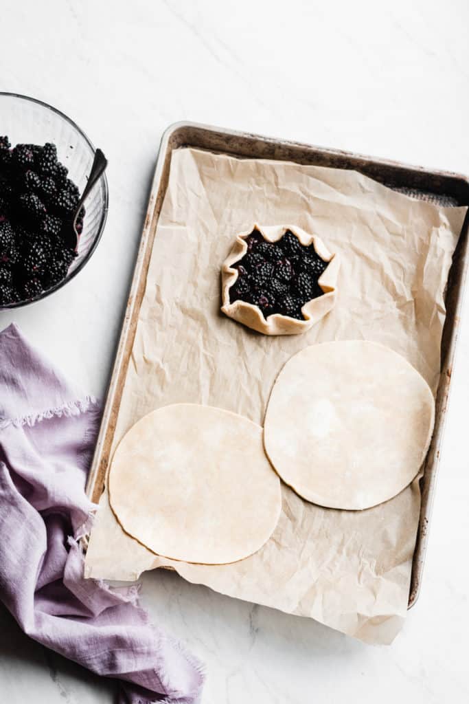 These galettes are made with an ultra flaky whole wheat pie crust and filled with a delicious red fruits spread & a simple blackberry fruit filling. Incredibly delicious, juicy, fresh, and lower in sugar – this is what New Year’s desserts look like, and I am fully on board. #galette #dessertrecipes #easyrecipes #healthyrecipes #healthydesserts #healthybaking #baking #blackberry #healthytreat #smallbatch #dessert #bluebowlrecipes | bluebowlrecipes.com