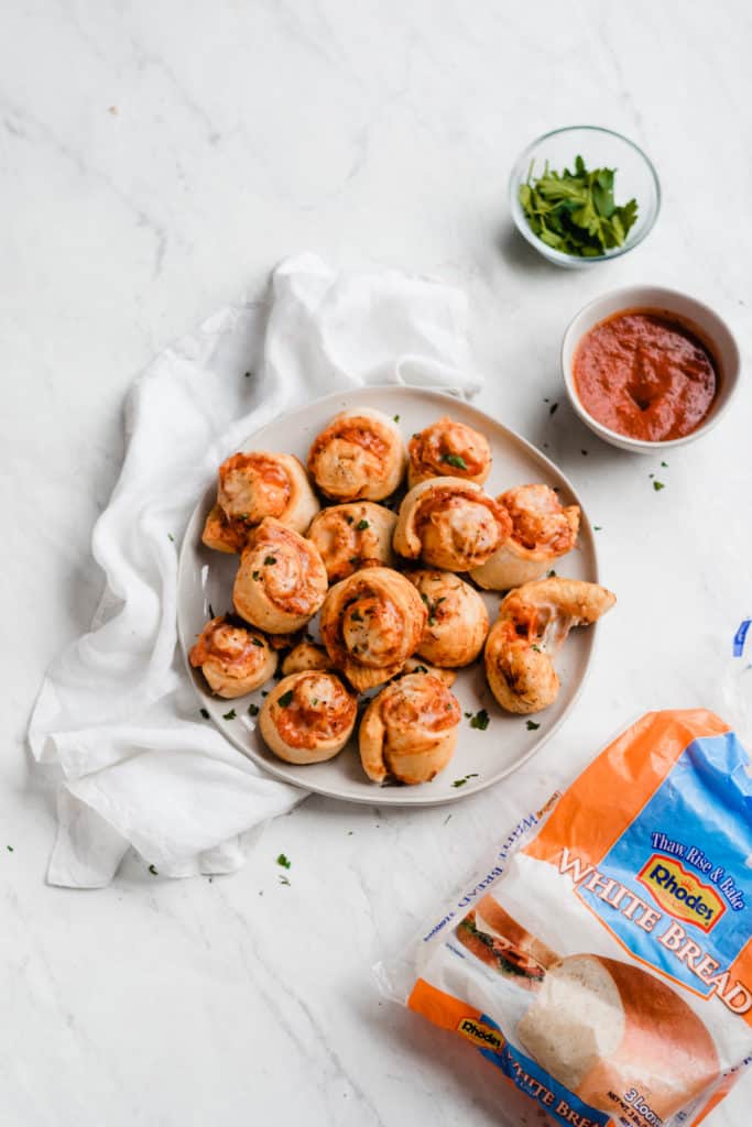 Easiest Homemade Pizza Rolls - These pizza rolls are stuffed with sauce, mozzarella cheese, pepperoni, and italian seasoning. Dip them in garlic butter or marinara sauce - YUM! This recipe can easily feed a crowd - it's the ultimate game day food! #pizzarolls #superbowlfood #superbowlrecipes #pizza #pepperoni #easyrecipes #superbowl #snackrecipes #appetizerrecipes #pizzarecipes #comfortfood #appetizers #snacks #bluebowlrecipes | bluebowlrecipes.com