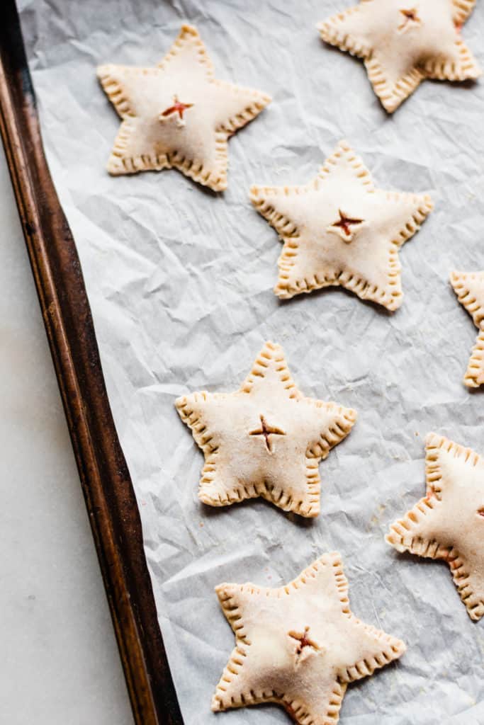 Unbaked star shaped hand pies on baking sheet