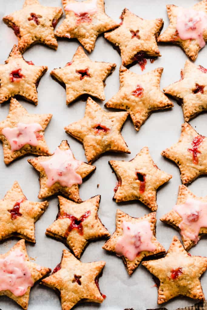 Freshly baked star shaped hand pies on tray with glaze