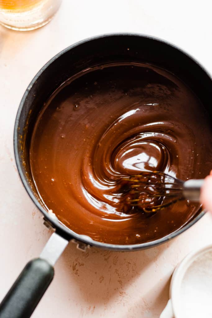 A bowl of caramel sauce being whisked up