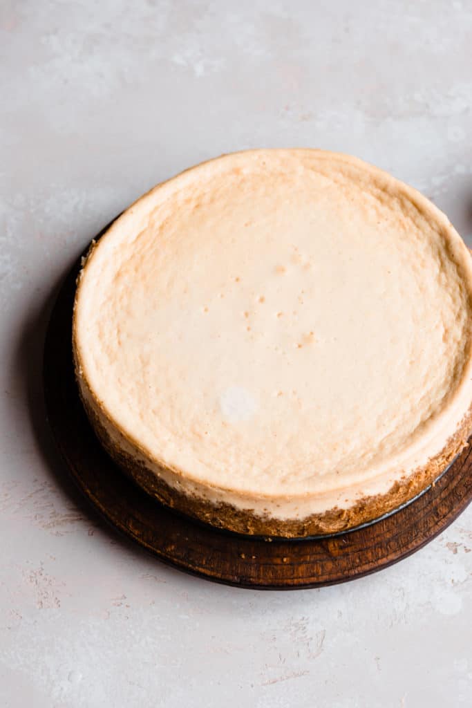 The plain, baked cheesecake sitting on a light surface