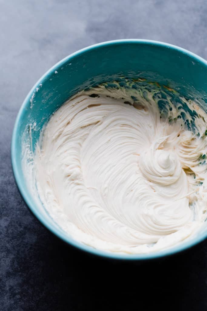 Smooth white frosting in a mixing bowl