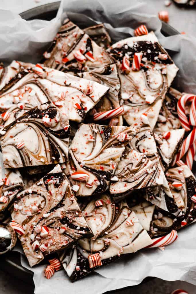 A close-up of the pieces of peppermint bark in the parchment paper lined pie dish